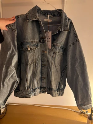 Oversized blå jeansjacka från GinaTricot  - Snygg oversized jeansjacka i klassisk ljusblå denim. Helt ny med prislapp. Nypris 600kr