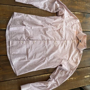 Ljuslila skjorta Riley  - Snygg ljuslila skjorta med klassisk krage och knappar framtill. Skjortan har lång ärm och är tillverkad i ett tunt, mjukt bomullstyg. Perfekt för dig som gillar stilrena plagg med enkel design. Storlek M men passar S också! 