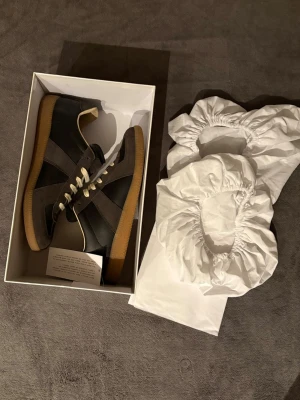 Maison Margiela gats - Säljer mina otroligt snygga svart/ gråa Maison Margiela gats. Dom är varsamt använda och i mycket fint skick. Köpte från Farfetch, kvitto/orderbekräftlese finns och kan därmed garantera autenticitet. Vid frågor eller om fler bilder önskas är det bara att fråga. Briset är diskuterbart.👊