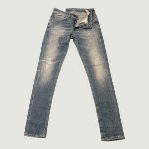 Dondup george ljusblå straight jeans - Snygga ljusblå jeans från dondup med slitna detaljer och klassisk femficksdesign. Jeansen har raka ben och subtila slitningar framtill för en cool, avslappnad look. Jeansen står att det är skinny fit, men de sitter mer relaxed/regular. Bakfickorna har dondup-logga och kontrastsömmar. Sjukt snygg selvedge tvätt, och coola kontrast! Tveka inte efter att ställa frågor