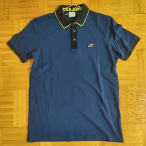 Pikétröja, Storlek M - Blå Jack & Jones pike med limegröna detaljer, för män, Helt ny aldrig använd, Storlek M, Väldigt bekväm rekommenderar starkt. PRIS KAN DISKUTERAS!