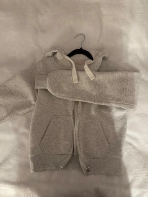 Ljusgrå zip hoodie med huva - Säljer en ljusgrå hoodie med dragkedja. 