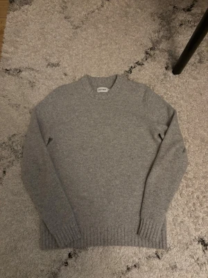 Grå stickad tröja från East West  - En stilren grå stickad tröja från East West som är i storlek M men den har krympt lite så passar kanske storlek S. Hör av er vid frågor!