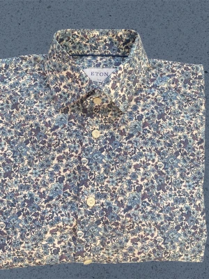 Blommig skjorta från Eton, slim fit - Snygg skjorta från Eton i slim fit med blommigt mönster i blått och vitt. Skjortan har klassisk krage och knäppning framtill. Perfekt för dig som vill sticka ut med stilrena detaljer och exklusivt tyg. Pris kan diskuteras vid snabb och smidig affär!!!!