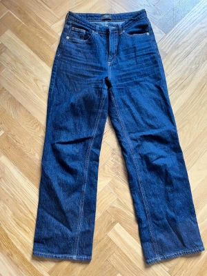 Mörkblå raka jeans från Vero Moda - Snygga mörkblå jeans från Vero Moda med rak passform och medelhög midja. Färgen är mer som på bild 2 i verkligheten. Storlek 28/30.