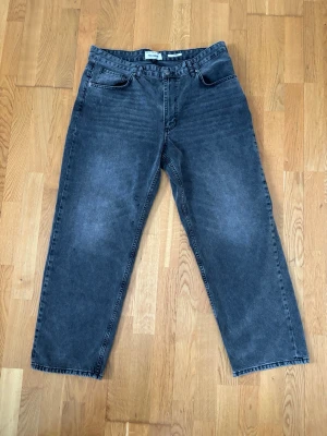 Baggy/Loose jeans - Pull & Bear  - Trendiga baggy/loose jeans i snygg grå/mörkgrå wash. Skön passform med bra fall och streetwear-vibe. Storlek W34 L34. Använda i fint skick utan större slitage. Perfekta till både oversized fits och vardag.  