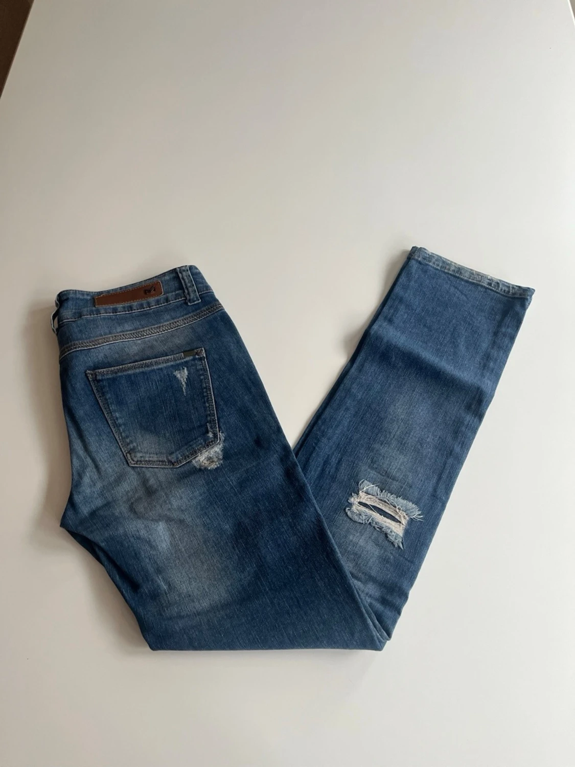 Blå slitna jeans med raka ben