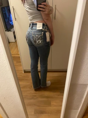 Miss me Bootcut Jeans  - Miss Me Bootcut jeans, midwaist. Storlek W27 L32. Helt nya med lapp kvar. Köpta på Raglady för 2599kr. Jätte fina detaljer på fickorna 