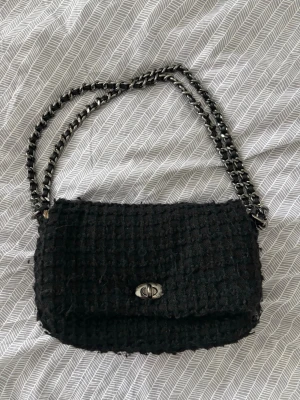 Svart väska med kedja - Svart väska från Beck söndergaard. Lite nopprig på vissa ställen, köpt för cirka 3 år sedan. 