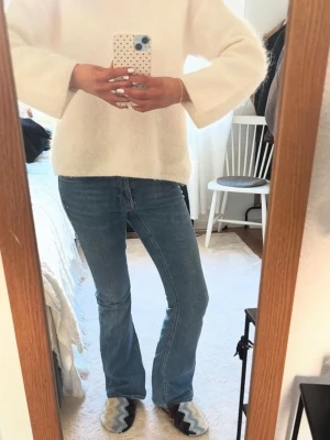 Blå bootcut jeans i klassisk modell - Säljer ett par blå bootcut jeans med normal midja och klassisk femficksdesign. Jeansen har en snygg tvätt och raka ben som går ut lite nedtill. Perfekta till en avslappnad och trendig look. Materialet är denim i bomull.