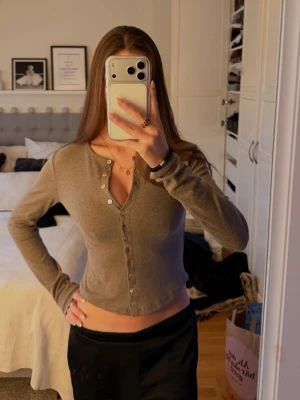 Grå/ brun  cardigan med knappar - Snygg grå/ brun cardigan med långa ärmar och v-ringning. Prislapp kvar, aldrig andvänd. 