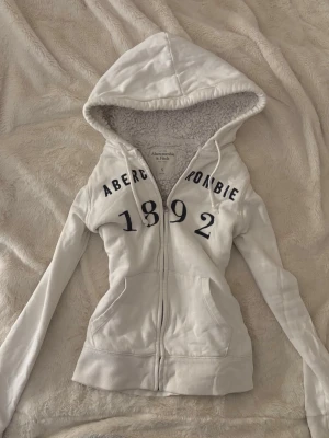 vinsten yk2 abercrombie zip huvtröja  - vintage vit abercrombie & fitch zip kofta med fluff inuti och svart text. bra skick och stl S!💕