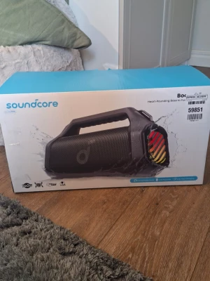 Soundcore Boom 2 Pro Bluetooth-högtalare - Soundcore Boom 2 Pro är en portabel trådlös högtalare med kraftfull bas och färgglada LED-ljus. Högtalaren är svart med robust handtag och grill i metall. Perfekt för att ta med ut tack vare vattentålig design och lång batteritid. Kopplas enkelt via Bluetooth.