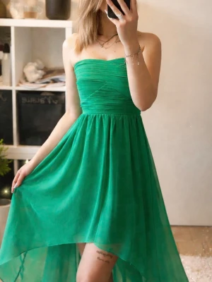 Grön axelbandslös asymmetrisk klänning - Säljer en snygg grön axelbandslös klänning med asymmetrisk nederkant. Klänningen har en draperad överdel och ett lätt, flödande tyg som ger en luftig känsla. Perfekt för sommarens alla tillfällen! (Pris går att diskuteras)