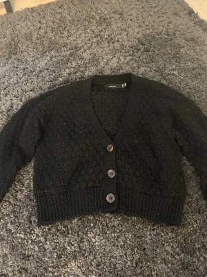 Svart stickad kofta med knappar - säljer min stickade kofta från vero moda då ja inte använder den längre. Den ser stor ut men den sitter bra på mig som har xs 