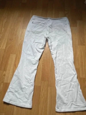 Vita bootcut+lågmidjade jeans - Säljer ett par vita bootcut jeans med klassisk femficksdesign. Jeansen har utsvängda ben och låg midja, perfekta för en cool look. Materialet är denim och de har bälteshällor samt knapp- och dragkedjegylf. Säljer för att jag hittat ett nyare par. De har inga fläckar eller defekter☺️ tveka inte att fråga om mått mm.