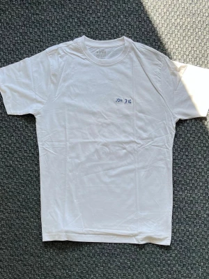 Handbroderad vit t-shirt från Denim Project - Vit T-shirt med handbroderad text ”Joh 3:16”. ”Ty så älskade Gud världen att han gav sin ende son, för att de som tror på honom inte skall gå under utan ha evigt liv."