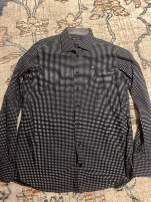 Svart skjorta med vitt mönster Park Lane - Snygg svart skjorta från Park Lane med vitt cirkelmönster och klassisk krage. Skjortan är i storlek XL !MEN! Den funkar för män i både storlek L och M, beroende på hur du gillar dina skjortor. Priset kan diskuteras.