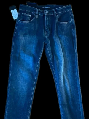 Raka Mörkblå Dolce Gabbana Jeans - Snygga mörkblå jeans med raka ben och tvättade detaljer framtill. Klassisk femficksmodell med knapp och dragkedja. Jeansen är gjorda i denim och har en stilren look som passar till det mesta. Perfekta för dig som gillar en enkel men trendig stil.