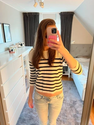 Randig trekvartsärmad topp💕 - Säljer en vit och svart randig topp med trekvartsärm. Toppen har en klassisk rund halsringning med knappar vid axlarna. Den är i väldigt fint skick och sparsamt använd. Den är normal i storleken 💕Priset kan diskuteras och kan posta fort💕