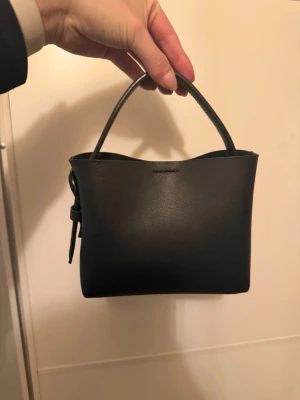 Arket miniväska - Köpt denna på vinted, blev inte nöjd med storleken. Fint skick, har en lite spricka på axelremmen som den förra ägaren satt väsktejp på. 