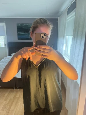 mörkgrönt linnetopp med v-ringning - Mörkgrön linnetopp med v-ringad hals och tunna axelband med gulddetalj💕