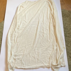 Krämfärgad tröja från Intimissimi - Ultralätt och mjuk tröja från Intimissimi i krämfärgad nyans. Tillverkad i en tunn blandning med kashmir för extra komfort. Tröjan har långa ärmar och en enkel, avslappnad passform. Designad i Italien och perfekt för lager på lager. Väldigt tunn och man ser igenom. Storlek L men passar mindre. ✨✨✨