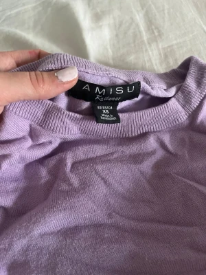 Ljuslila stickad tröja från Amisu - Säljer en ljuslila stickad tröja från Amisu i storlek XS. Tröjan har rund halsringning, långa ärmar och ribbade muddar vid ärmslut och nederkant. Perfekt för dig som gillar mjuka och enkla basplagg i snygg pastellfärg.