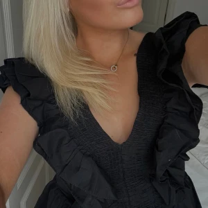 Svart volangblus med v-ringning - Säljer min ”trendiga” svarta blus med djup v-ringning och stora volangdetaljer. Storlek M men skulle säga att den passar S också! Perfekt till sommaren eller vad som💞