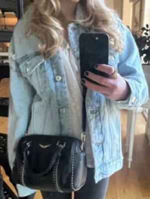 Ljusblå oversized jeansjacka - Säljer en ljusblå oversized jeansjacka med klassiska bröstfickor och silverfärgade knappar. Jackan har en avslappnad passform och är perfekt att slänga över en hoodie eller t-shirt. Snygg vintage vibe och passar till allt i garderoben.