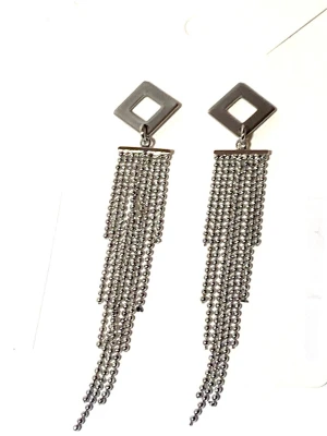 Silvriga långa örhängen med kedjor - Säljer ett par silvriga örhängen med geometrisk fyrkant upptill och flera hängande kedjor av små pärlor. Örhängena har en modern och edgy look, perfekta för att sticka ut. Materialet är i rostfritt stål och äkta silver  och designen är riktigt trendig.                Längd / 7.5cm 