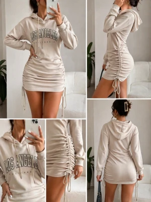Beige hoodieklänning med snörning - Trendig beige hoodieklänning med snörning på sidorna och texten 'Los Angeles California' på bröstet. Klänningen har långärmad design, huva med dragsko och en croppad, tight passform som framhäver figuren. Perfekt för dig som gillar streetstyle och comfy mode. Superfin men aldrig använd, kan ha tvättat den dock. Höjd ca 165-170 cm.