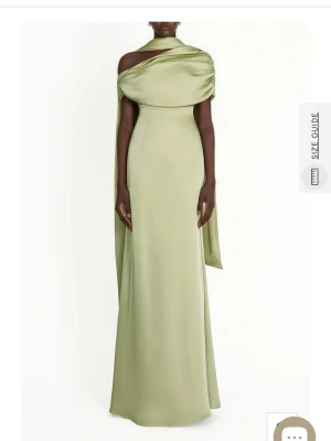 Ljusgrön långklänning i satin - Elegant ljusgrön långklänning i satin med oneshoulder-design och draperad överdel. Klänningen har en slät, figurnära passform och ett långt, svepande fall. Perfekt för dig som vill sticka ut med en unik och sofistikerad look. Klänningen är helt ny och oanvänd, säljs då paketet kom försent. Nypris är 1675 kr