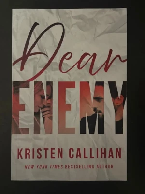 Dear Enemy av Kristen Callihan - En modern skönlitterär roman med titeln 'Dear Enemy' av Kristen Callihan. Omslaget är vitt med stora röda och svarta bokstäver och har bilder av två personer integrerade i texten. Perfekt för dig som gillar romantik och drama.