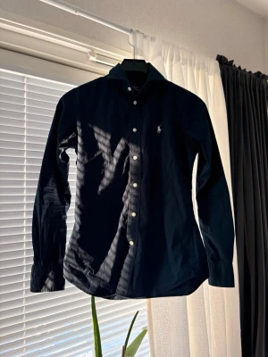 Ralph Lauren skjorta - Säljer en fin navy Ralph Lauren skjorta i nästan nytt skick. Storlek XS. Hör av dig ifall du är intresserad 🙌
