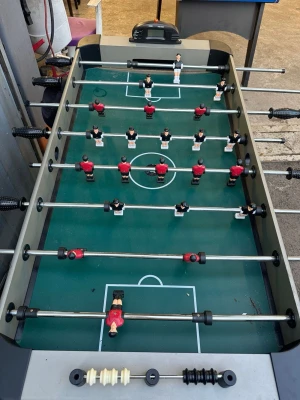 Biljards bord  - Säljer ett klassiskt fotbollsspel bord i grått med svarta detaljer. Spelplanen är grön och spelarna är i rött och svart. Bordet har svarta handtag och poängräknare i vitt och svart. Perfekt för att utmana vänner på matcher hemma eller i fritidsrummet.