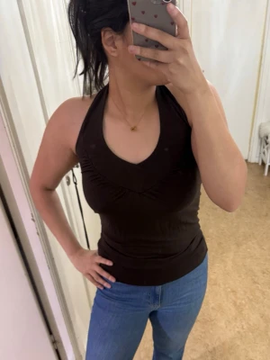 Mörkbrun halterneck-topp – Gina Tricot – XS - Säljer en jättesnygg mörkbrun topp i halterneck-modell från Gina Tricot. Skick: Bra. Perfekt för sommaren! Storlek XS