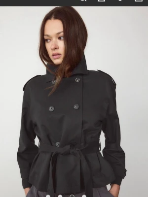 Kort svart trenchcoat med bälte - Intressekoll på denna kappa från Stradivarius. Pris går att diskutera. Ej använd endast testad en gång. 