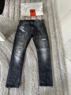 Replay Rocco Jeans  - Riktigt snygga replay jeans i storlek 27x30 med slitningar. Jeansen är helt nya. På sista bild ser ni bild på hur de sitter (Jag är 175). Modellen är replay Rocco 