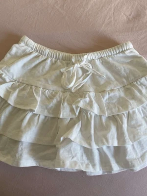 Vit volangkjol - Vit kjol med volanger med knyt där framme ifrån Gina tricot i storlek xs💓använd fåtal gånger 