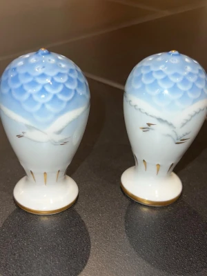 Bing & Grøndahl Salt- och pepparströare - Ett par salt- och pepparströare från Bing & Grøndahl. Ströarna är vita med blått mönster upptill och gulddetaljer. Blåmåsen serien.