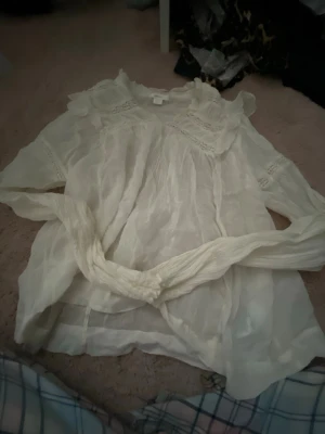 Vit blus med spetsdetaljer - vit blus aldrig andvänd mycket bra skick ,dm mig om du vill se hur den sitter på.