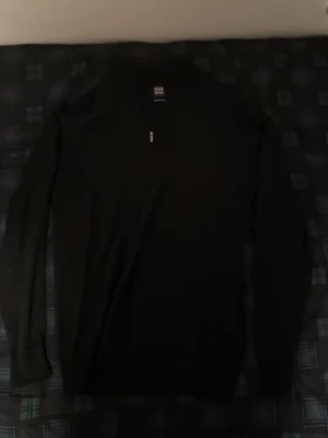 Svart merinoullströja från Boggi Milano - Snygg svart stickad tröja från Boggi Milano i extrafin merinoull. Tröjan har halv dragkedja vid halsen och lång ärm, perfekt för dig som gillar stilrena och klassiska plagg med en modern touch.