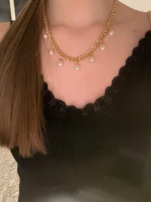 Guldhalsband med pärldroppar - Snyggt halsband i guldfärgad metall med chunky kedja och hängande vita pärldroppar. Justerbar längd med karbinlås. Perfekt för att ge en trendig touch till din outfit. Handgjort