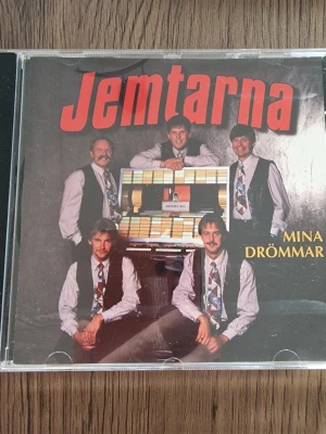 Jemtarnas Mina drömmar CD-album - Jemtarnas Mina drömmar CD-album. Musik i genren mogen dansmusik från Jämtland. Skivan innehåller låtarna: "Peppelinos bar", "En människa av idag", "I just listen to my heart", "Mina drömmar", "All I have to do is dream" och "Good luck charm". Levereras i standard plastfodral med tryckt omslag fram och bak.