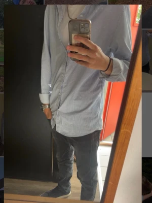 Blåvit randig skjorta från Zara - Säljer en slim fit skjorta från Zara i blåvitt randigt mönster. Skjortan har långa ärmar, klassisk krage och knäppning framtill. Perfekt för dig som gillar en clean och stilren look. Tillverkad i bomull för skön känsla.