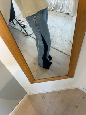 Lågmidjade coola jeans - Säljer ett par omsydda jeans från weekday. Ljust blåa med mörkblåa detaljer. Jeansen har låg midja, i bra skick.