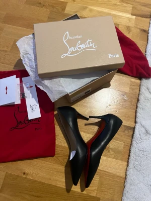 Svarta läder klackar från Christian Louboutin - Stilrena svarta pumps från Christian Louboutin med den ikoniska röda sulan. HELT NY OCH OANVÄND!Skorna är tillverkade i slätt läder och har en klassisk spetsig tå och hög klack. Innersulan är beige med guldfärgad logotyp. Perfekt för din kommande bal eller din nästa lyxiga utekväll!