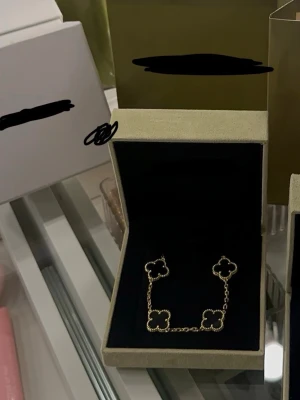 Guldigt armband med fyrklöver - Snyggt armband i guldton med flera fyrklöverformade hängen. Kedjan är tunn och elegant, och armbandet har en exklusiv känsla. Perfekt accessoar för dig som gillar stilrena smycken med unik design.