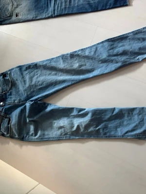 Ljusblå  jeans från reaply - Säljer ett par ljusblå jeans från reaply med en klassisk femficksdesign. Jeansen har en snygg tvättad look och är tillverkade i denim. Perfekta för en avslappnad stil och passar till det mesta i garderoben.
